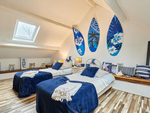 - 2 lits dans une chambre avec des planches de surf sur le mur dans l'établissement Holiday Home Le Hamelinet by Interhome, à Surville