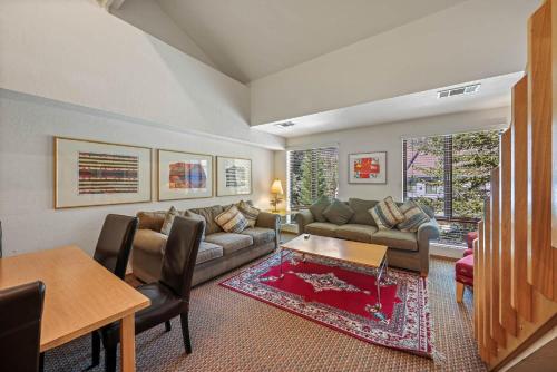 a living room with a couch and a table at Palisades Tahoe Lodge Rentals Studio Loft #305 in Olympic Valley