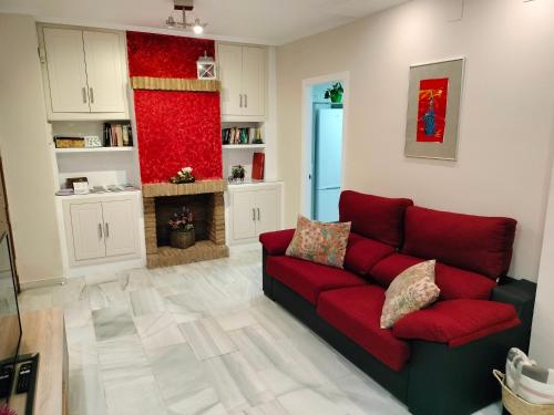 a living room with a red couch and a fireplace at Acogedor apartamento. Mezquita Wifi in Córdoba