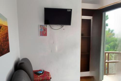 sala de estar con TV de pantalla plana en la pared en Villa Ayem en Magetan