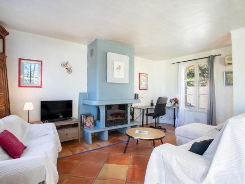 Una sala de estar con un sofá y una chimenea. en Villa Les Mûriers by Interhome, en Cogolin