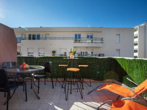 un patio avec une table et des chaises et un bâtiment dans l'établissement Apartment Villa Emeraude by Interhome, à Cagnes-sur-Mer