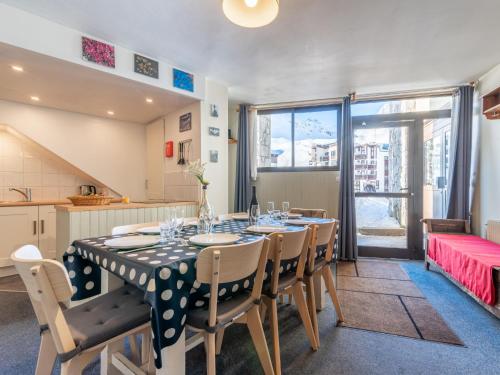 a dining room with a table and chairs and a kitchen at Apartment Les Hauts du Val Claret - Val Claret-24 by Interhome in Tignes