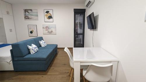伊加洛的住宿－Adria By The Sea - AB，客厅配有蓝色的沙发和桌子