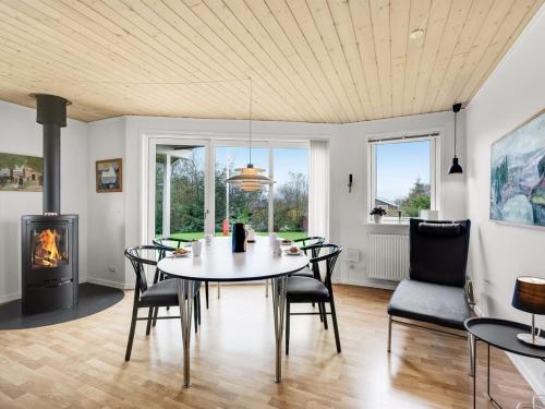 une salle à manger avec une table, des chaises et une cheminée dans l'établissement Holiday Home Ensio - 300m to the inlet in The Liim Fiord by Interhome, à Vinderup