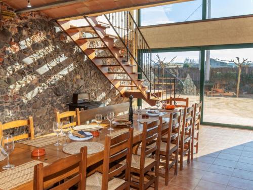 a dining room with a table and chairs and a stone wall at Holiday Home Can Borni by Interhome in Vidreres