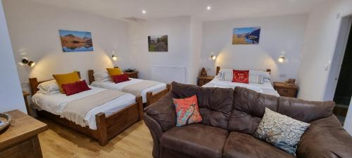 a living room with two beds and a couch at Wastwater Cottage on The Big "W" Ranch in Nether Wasdale