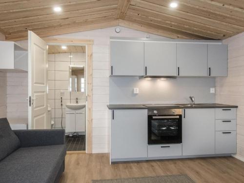 eine Küche mit weißen Schränken und einem Sofa in einem Zimmer in der Unterkunft Holiday Home Pikkuporo f by Interhome in Saariselkä