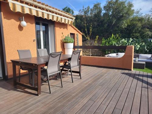 una terraza de madera con mesa y sillas de madera en Holiday Home La Maison château vert by Interhome, en Sanary-sur-Mer