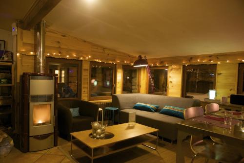 ein Wohnzimmer mit Sofa und Kamin in der Unterkunft Le Chalet Viso Auberge gite in Arvieux