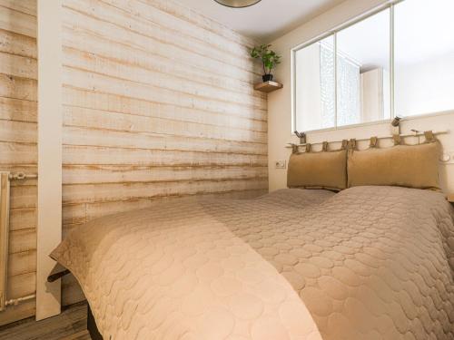 1 dormitorio con 1 cama con pared de madera en Apartment Les Arènes de Cimiez by Interhome, en Niza
