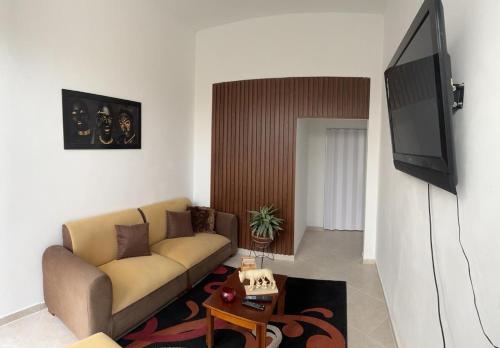 ein Wohnzimmer mit einem Sofa und einem Flachbild-TV in der Unterkunft Apartamentos ANGEL'S in Buga