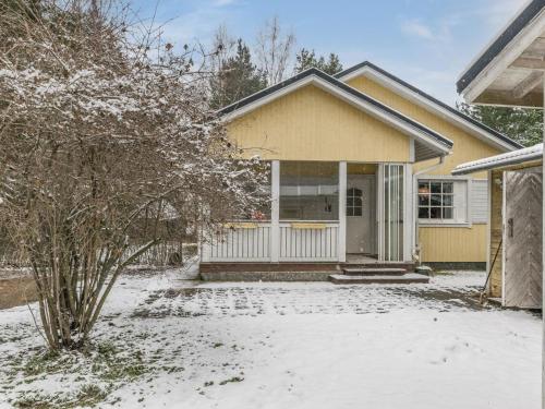 una casa amarilla con nieve en el suelo en Holiday Home Villa heikinniemi by Interhome en Joutsa