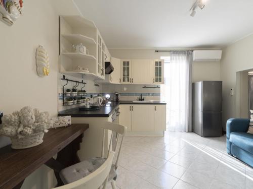a kitchen with white cabinets and a blue couch at Apartment il Rifugio by Interhome in Bordighera