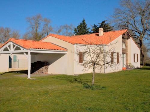 een wit huis met een oranje dak in een tuin bij Holiday Home Charme de la Fradinière by Interhome in Saint-Hilaire-de-Riez