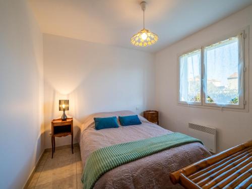une chambre avec un lit avec des oreillers bleus et une fenêtre dans l'établissement Holiday Home Maison des Pins Parasol by Interhome, à Plaissan