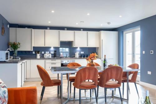 a kitchen with a dining room table and chairs at Elliot Oliver - Luxury Three Bedroom Town Centre Apartment With Parking in Cheltenham