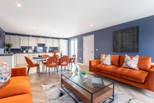 a living room with an orange couch and a table at Elliot Oliver - Luxury Three Bedroom Town Centre Apartment With Parking in Cheltenham