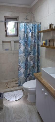 a bathroom with a toilet and a shower curtain at SEMEREL APARTMENT in Palm-Eagle Beach