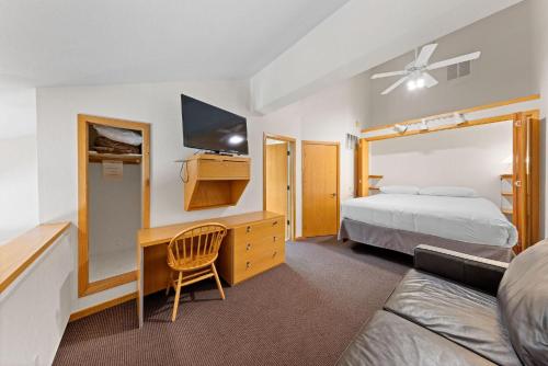 a bedroom with a bed and a desk with a tv at Palisades Tahoe Lodge Rentals Studio Loft #314 in Olympic Valley