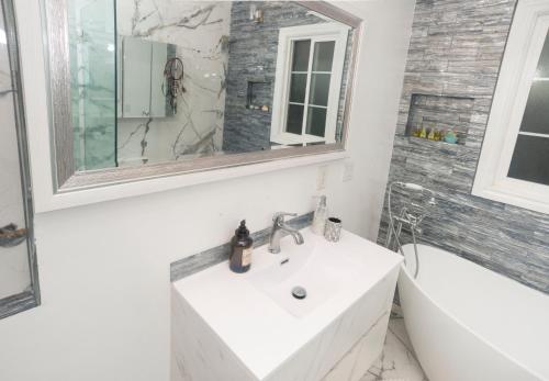 Baño blanco con lavabo y bañera en Blanquitas Home en Long Beach