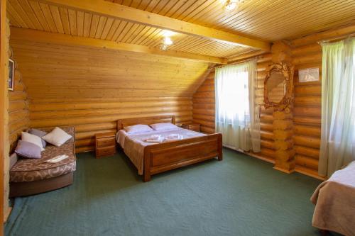 a bedroom with two beds in a log cabin at Садиба У Василини та Романа in Bukovel