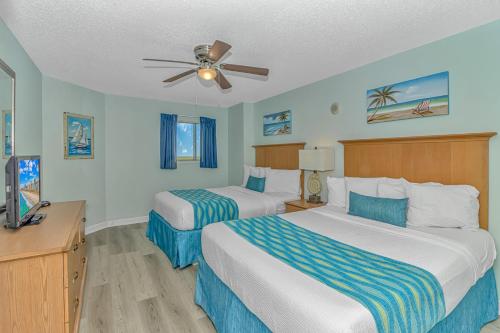 ein Hotelzimmer mit 2 Betten und einem Deckenventilator in der Unterkunft Paradise 1408 in Myrtle Beach