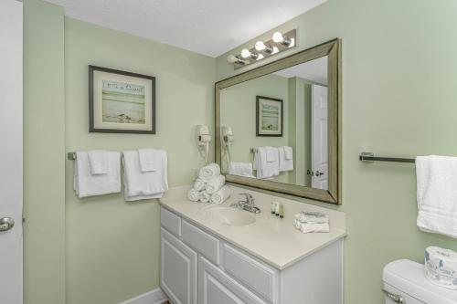 ein weißes Badezimmer mit einem Waschbecken und einem Spiegel in der Unterkunft Paradise 1408 in Myrtle Beach