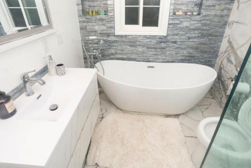 a bathroom with a tub and a sink and a toilet at Blanquitas Home in Long Beach