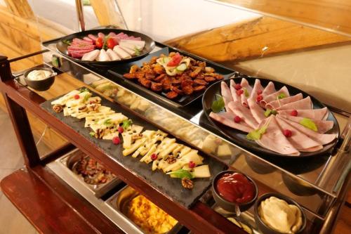 een buffet met veel verschillende soorten eten erop bij Kastélyszálló Wellness Resort Sóstó in Igricetanya