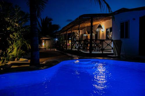 a blue pool in front of a house at night at Villa Kikadini in Jambiani