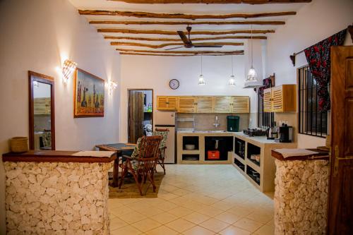 a kitchen with a table and a dining room at Villa Kikadini in Jambiani