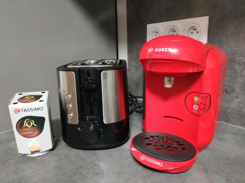 a red coffee maker and a toaster next to a box at BOUCHON POUR 4 Avenue de Champagne à 3 minutes in Épernay