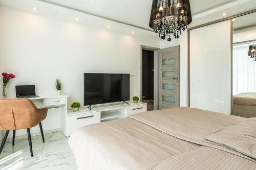 a white bedroom with a bed and a television at Holiday House Ratvaj 