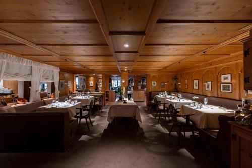 a dining room with tables and chairs and wooden ceilings at Hotel Zum Ochsen in Schonwald im Schwarzwald