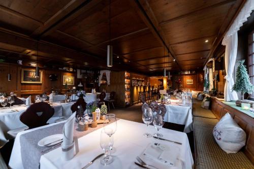 a restaurant with white tables and chairs with wine glasses at Hotel Zum Ochsen in Schonwald im Schwarzwald