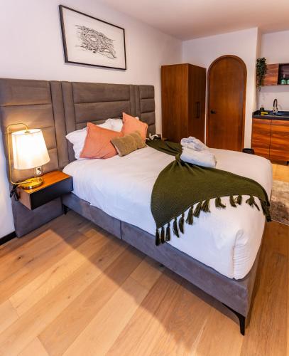 a bedroom with a large bed and a lamp at Casa Castillo in Mexico City