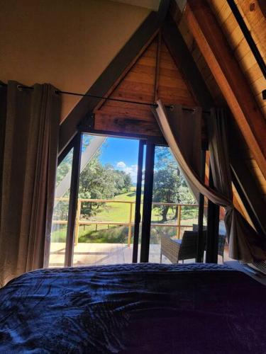 a bedroom with a bed and a large window at Le Petite Chalet Mazamitla in Mazamitla