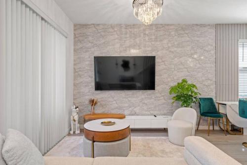sala de estar con TV en una pared de piedra en Luxury Townhouse All Suite Near Disney Universal, en Kissimmee