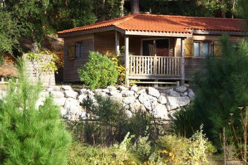 a small house with a rock wall in front of it at Naturéo in Seignosse