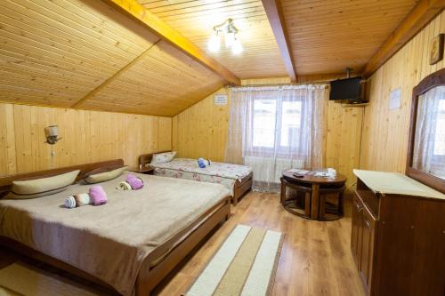 a bedroom with two beds and a table in a room at Садиба У Василини та Романа in Bukovel