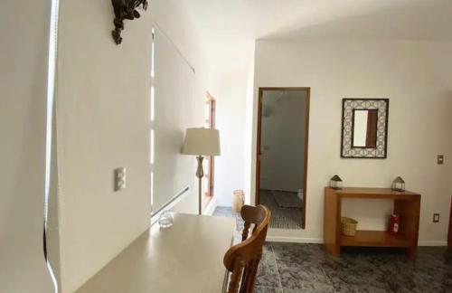 Jest to biały pokój ze stołem i lustrem. w obiekcie Comoda habitacion con baño privado morelos 1 w mieście Querétaro