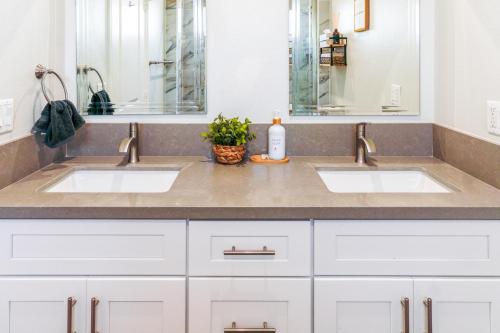 ein Badezimmer mit zwei Waschbecken und einem Spiegel in der Unterkunft Cozy Luxe Unit Near Disneyland - Sleeps up to 10! EV Friendly & King Bed in Midway City