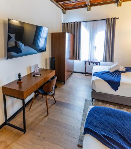 a hotel room with two beds and a desk at Casa Castillo in Mexico City