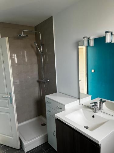 a bathroom with a sink and a shower with a mirror at Maison en travaux bientôt disponible in Oye-Plage