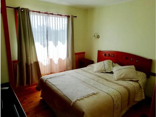 a bedroom with a bed and a large window at Cabañas & Camping Memoruz in La Higuera