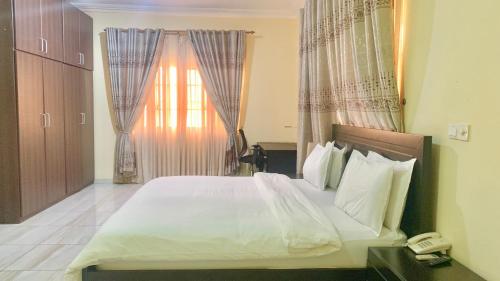 a bedroom with a large bed with a phone next to a window at Royals 2 bedrooms Luxury in Accra