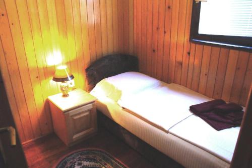 ein Schlafzimmer mit einem Bett und einer Lampe auf einem Tisch in der Unterkunft Chalet Ravnjak at Tara Springs Park in Žabljak