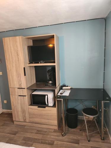 Cette chambre comprend une armoire avec un four micro-ondes et un bureau. dans l'établissement La Villa du MOULIN DE MADAME, à Bias