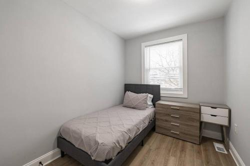 um quarto com uma cama, uma cómoda e uma janela em Modern LUX 3BR Updated Townhome w/ Parking em Washington